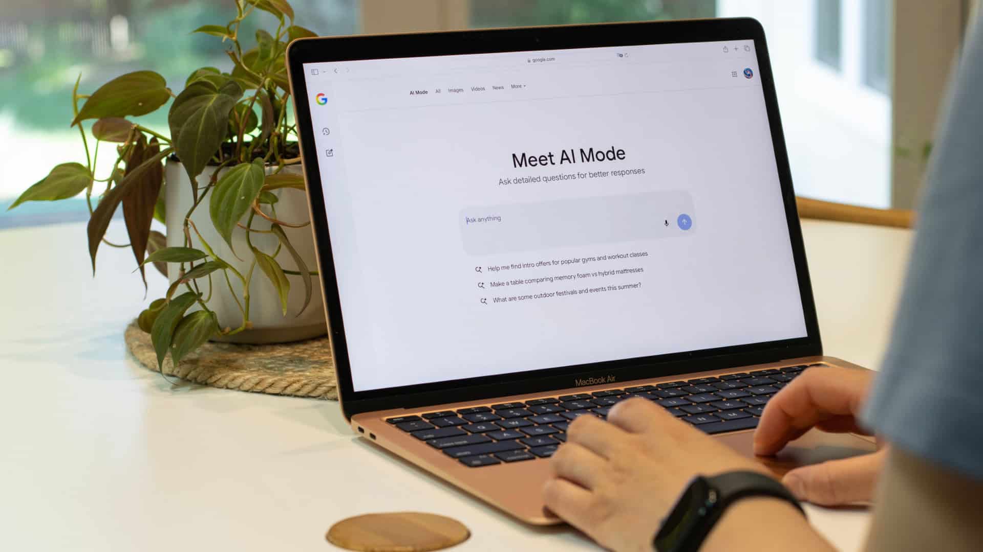 Pessoa mexe em notebook com a tela na página do Google AI Mode