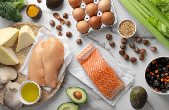 mesa com salmão, peito de frango, queijos, cogumelos e outros alimentos que possuem proteina