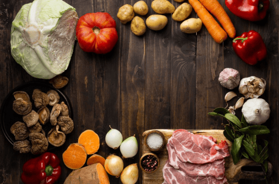 vegetais e carnes sobre uma mesa de madeira