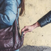 Homem roubando celular de bolsa de mulher
