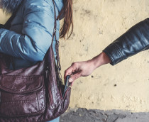 Homem roubando celular de bolsa de mulher