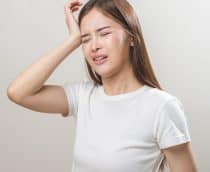 Jovem asiática com dor de cabeça ou enxaqueca, sofrendo de vertigem