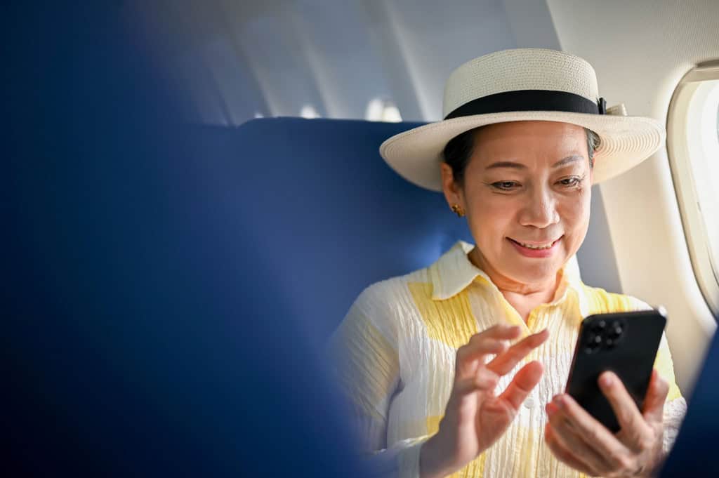 Turista mexendo no celular em e=avião