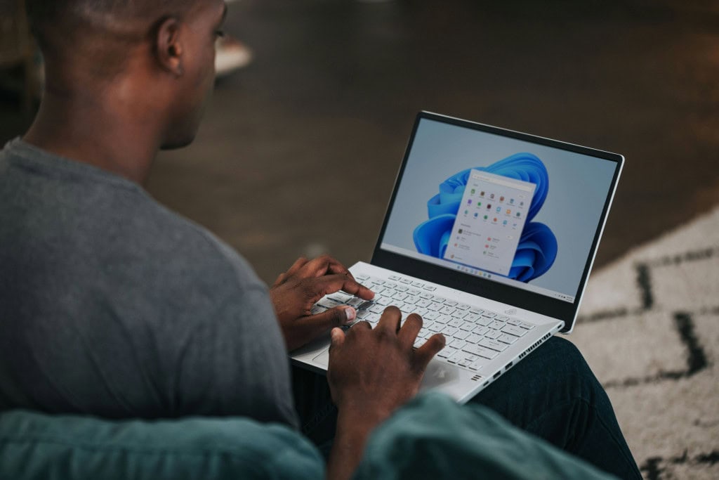 Imagem ilustrativa de homem usando Windows 11 no laptop