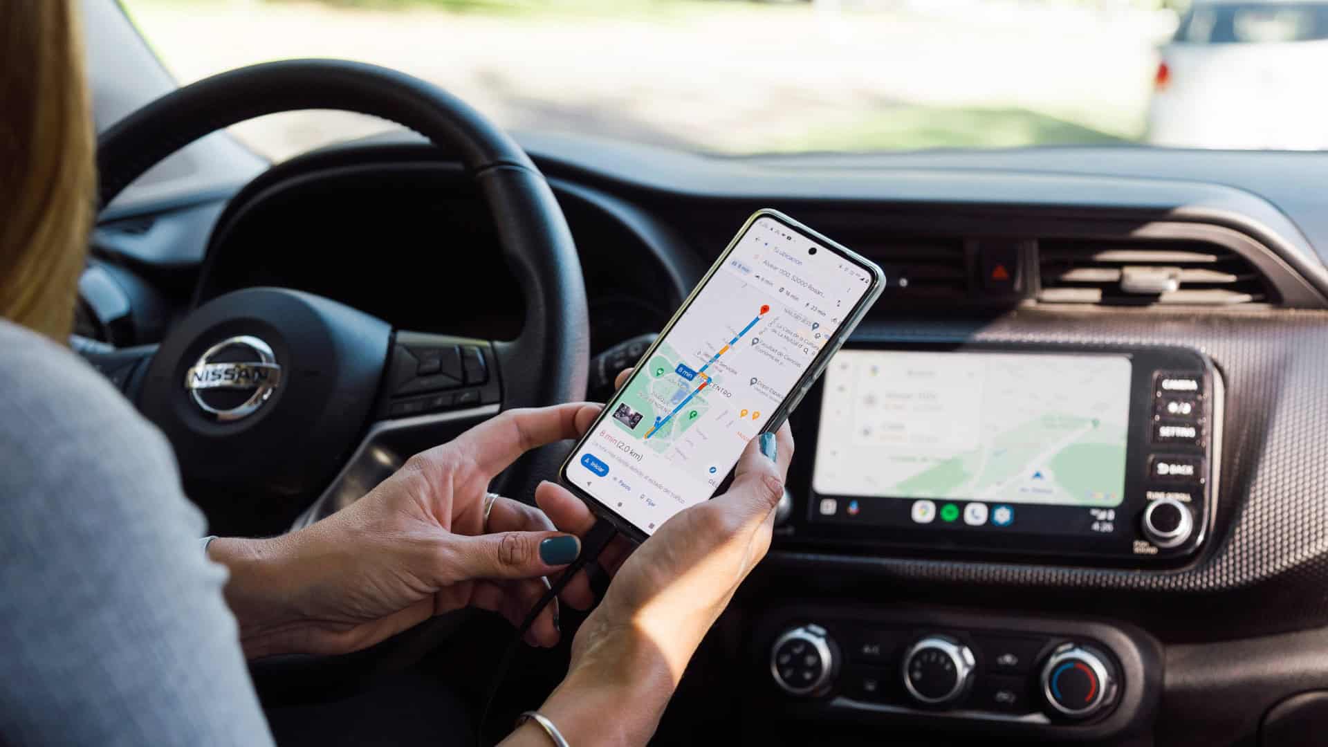 Mulher conecta Android Auto pelo celular via cabo para acessar aplicativo de navegação Google Maps
