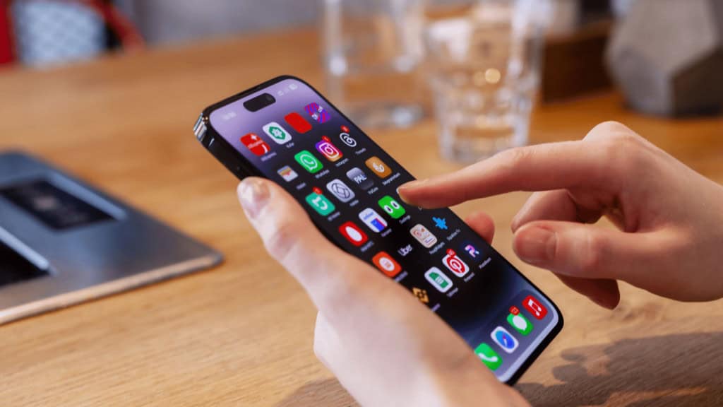 Pessoa utilizando um celular  com vários aplicativos