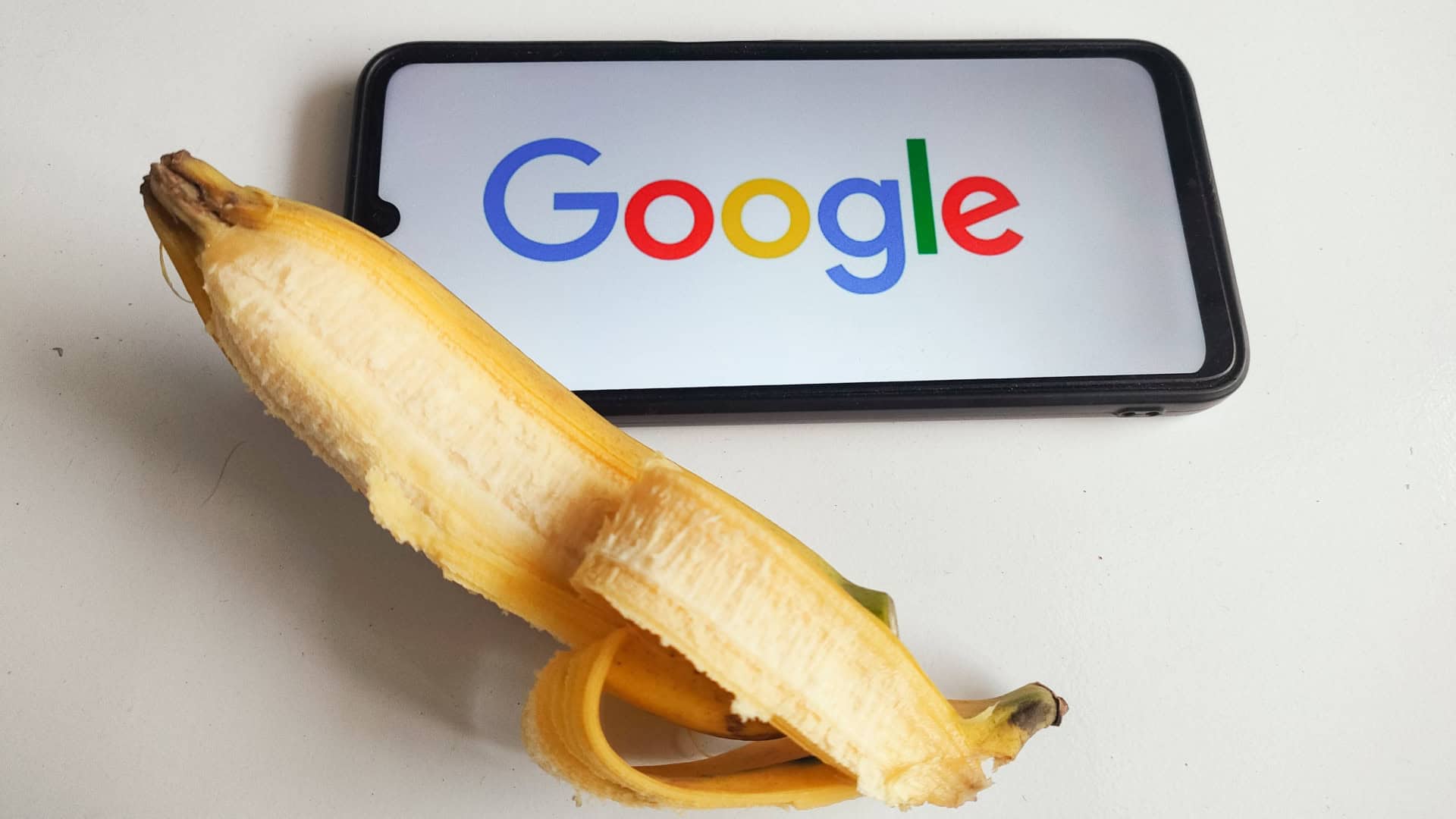 Banana ao lado de celular com logotipo do Google na tela