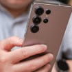 Homem segurando um Galaxy S25 Ultra, da Samsung; foto mostra a parte traseira do celular