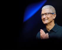 CEO da Apple, Tim Cook, olhando para o lado e sorrindo, com mãos juntas em gesto de gratidão
