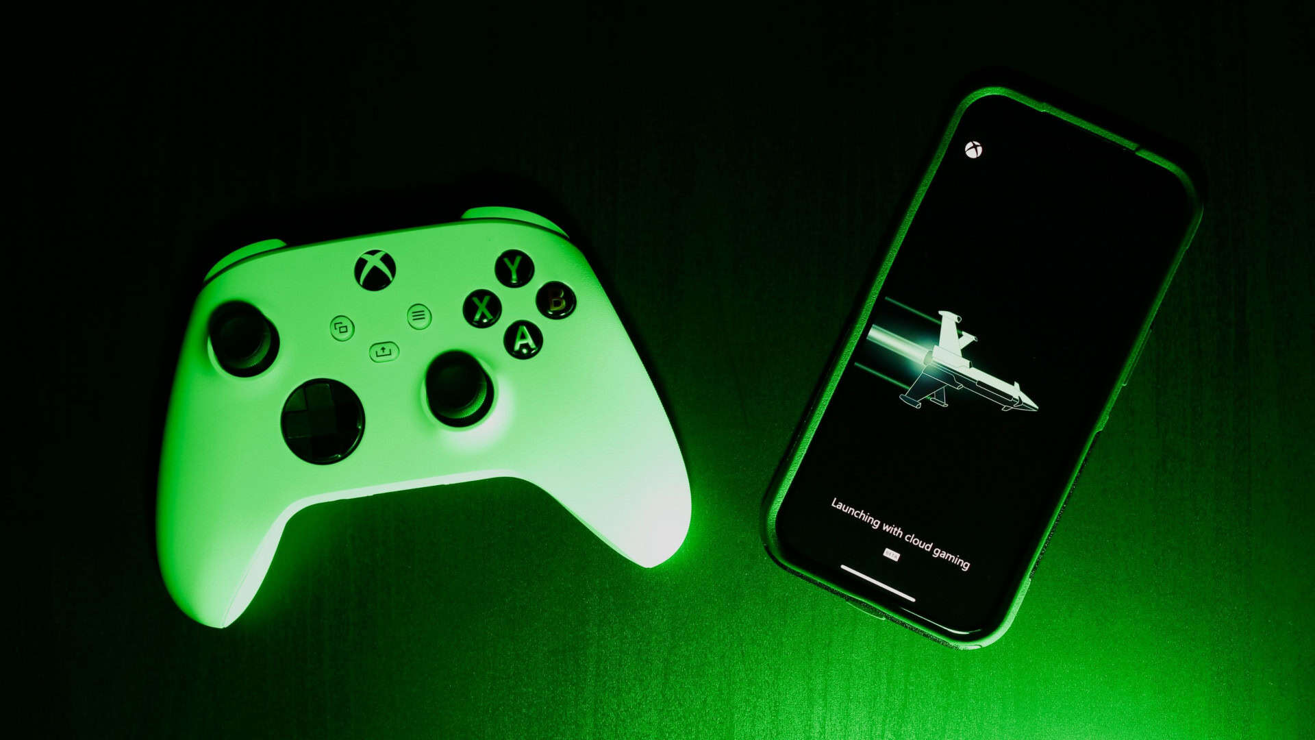 Controle de Xbox ao lado de iPhone carregando jogo no Xbox Cloud Gaming