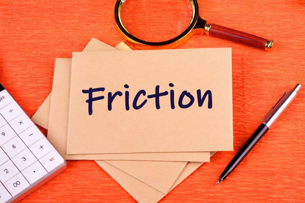 Papel com os dizeres "Friction"; acima, uma lupa; abaixo, uma caneta