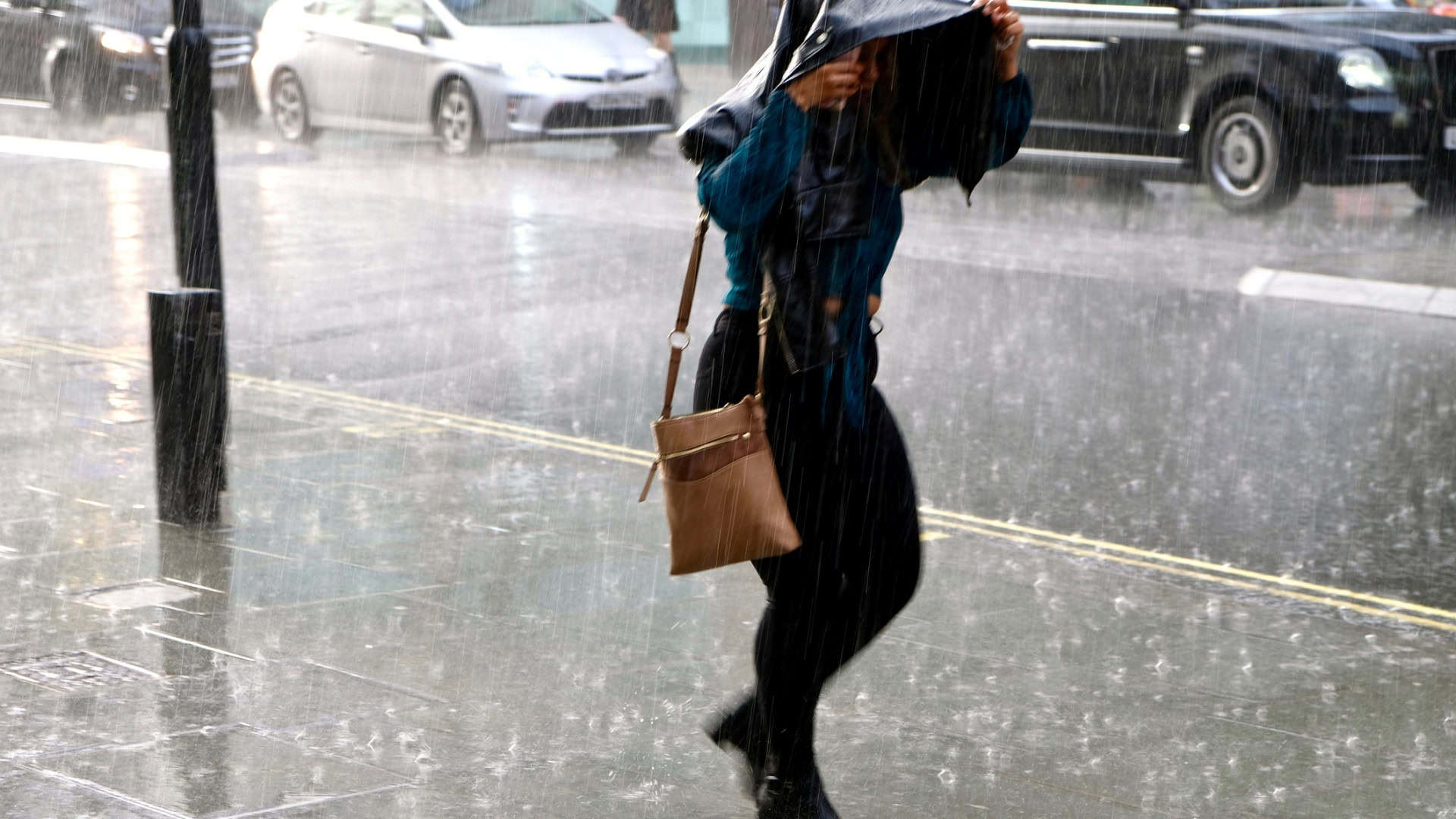Pessoa com uma bolsa em cima da cabeça durante chuva