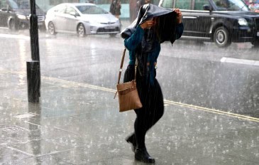 Pessoa com uma bolsa em cima da cabeça durante chuva