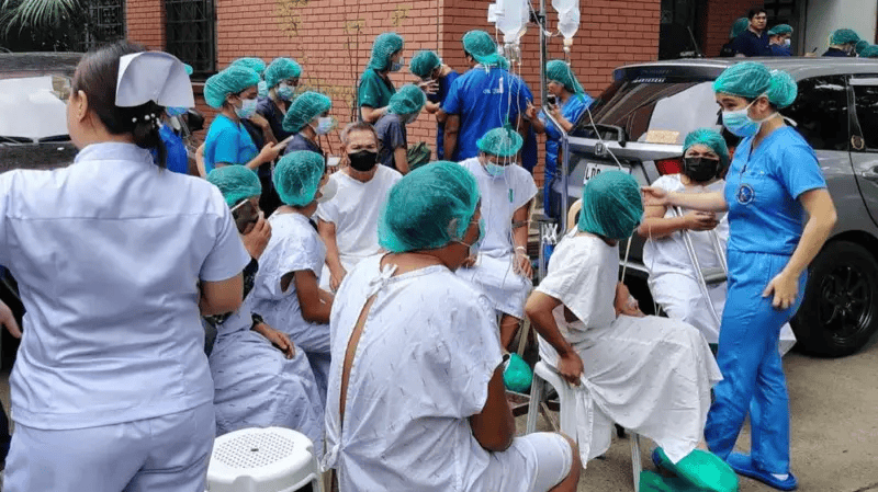 Pessoas com roupas de hospital do lado de fora