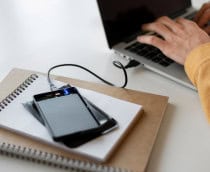 pessoa usando o notebook com um ssd externo conectado