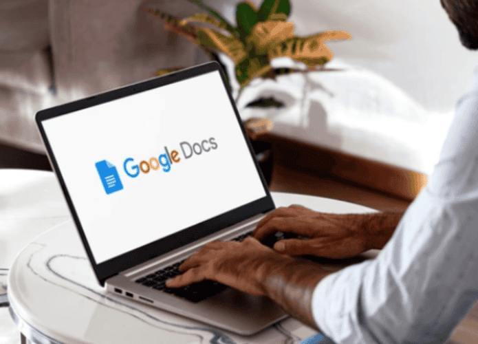 homem usando google docs em um notebook em cima de uma mesa