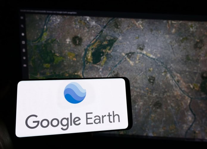 Ao fundo, mapa do Google Earth; à frente, logo do serviço em um smartphone na horizontal