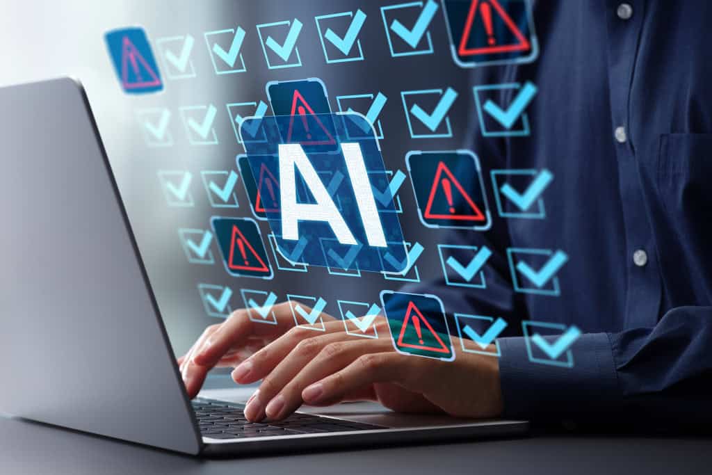 Pessoa teclando em um notebook e os dizeres "AI" pairando em cima