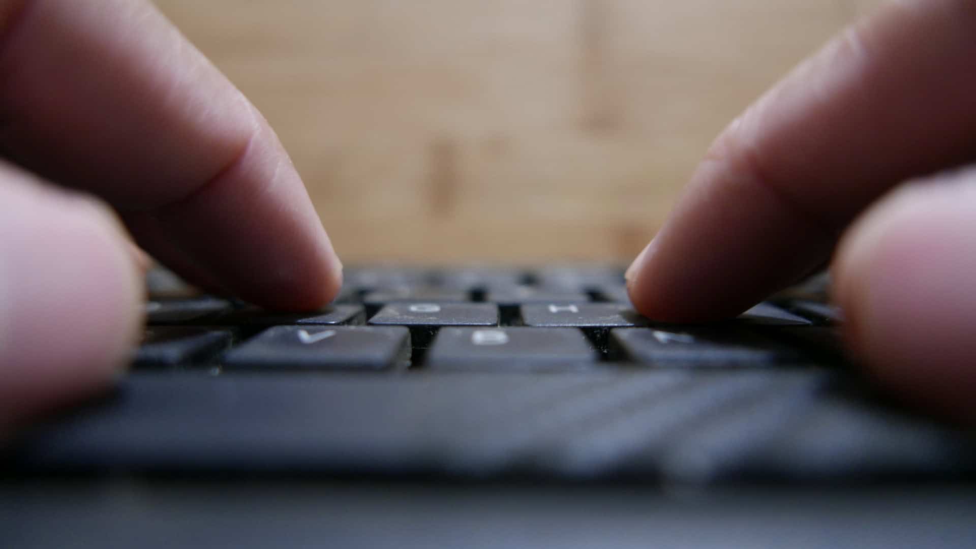 Pessoa teclando em um teclado de computador
