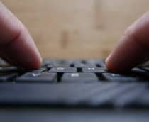 Pessoa teclando em um teclado de computador
