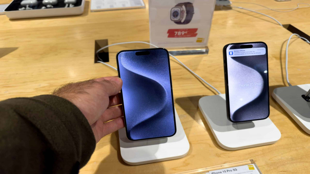 Imagem mostra uma mão masculina segurando um Apple iPhone 15 Pro Max exibe em detalhes seu corpo de titânio premium e a luxuosa tela OLED