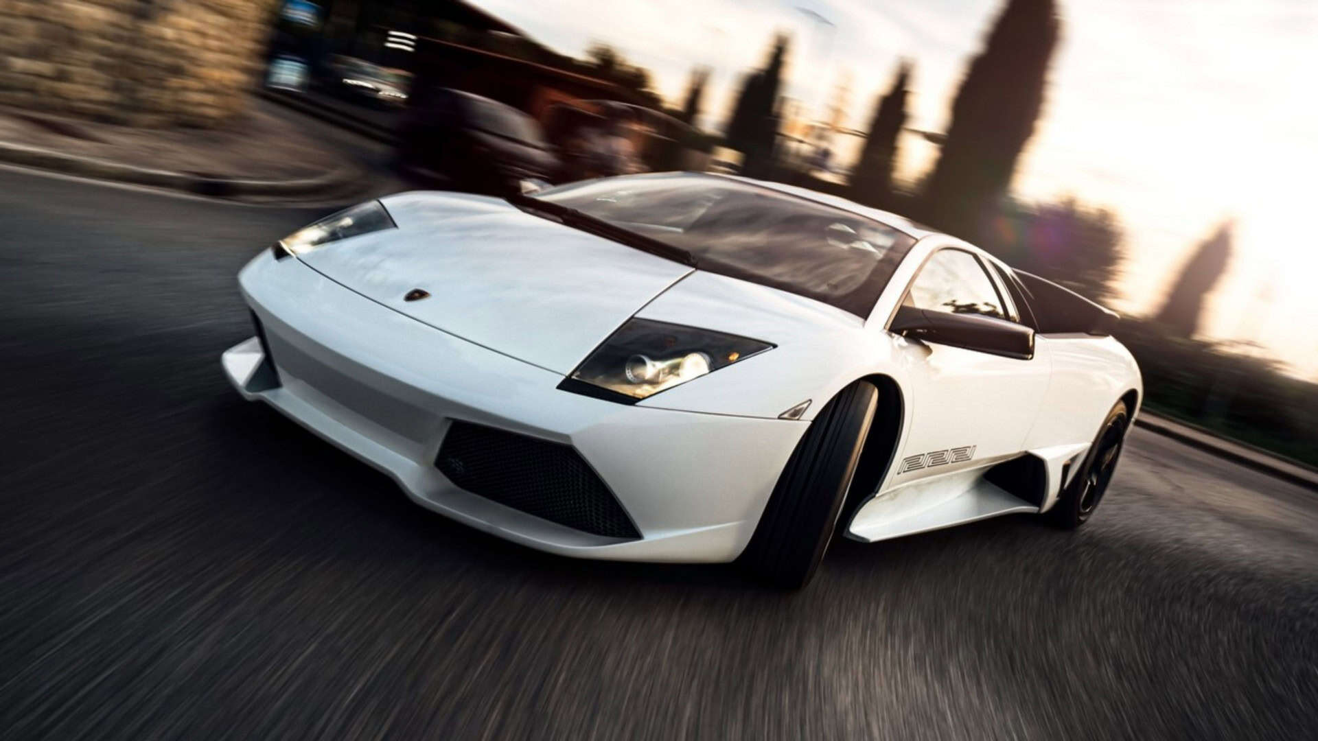 foto de um carro Murciélago branco da Lamborghini, em uma estrada de asfalto