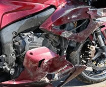 Imagem mostra close de motocicleta esportiva danificada após uma queda em uma corrida