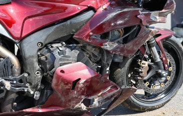 Imagem mostra close de motocicleta esportiva danificada após uma queda em uma corrida