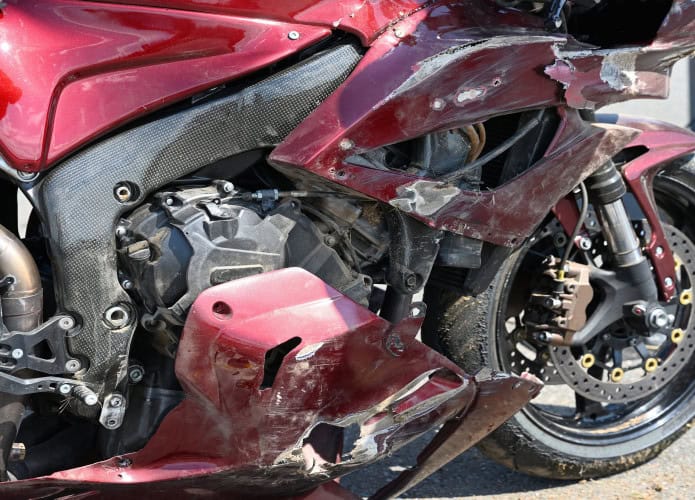 Imagem mostra close de motocicleta esportiva danificada após uma queda em uma corrida