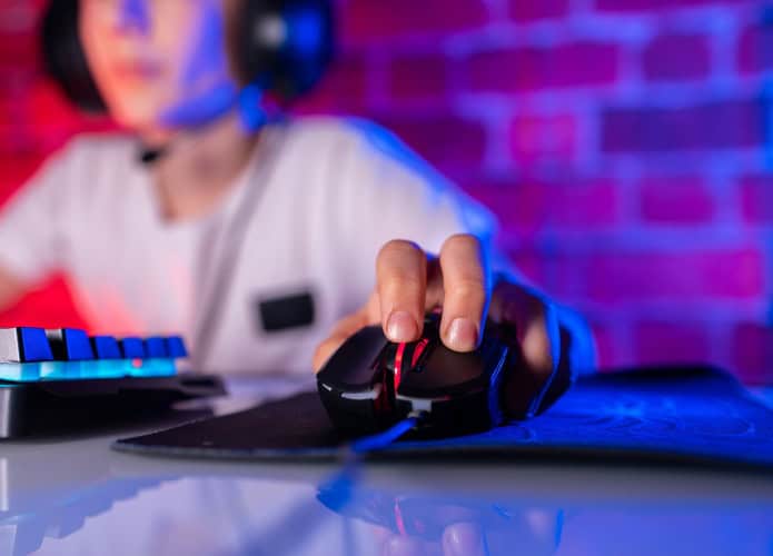 Close de garoto usando fone de ouvido e com a mão em um mouse