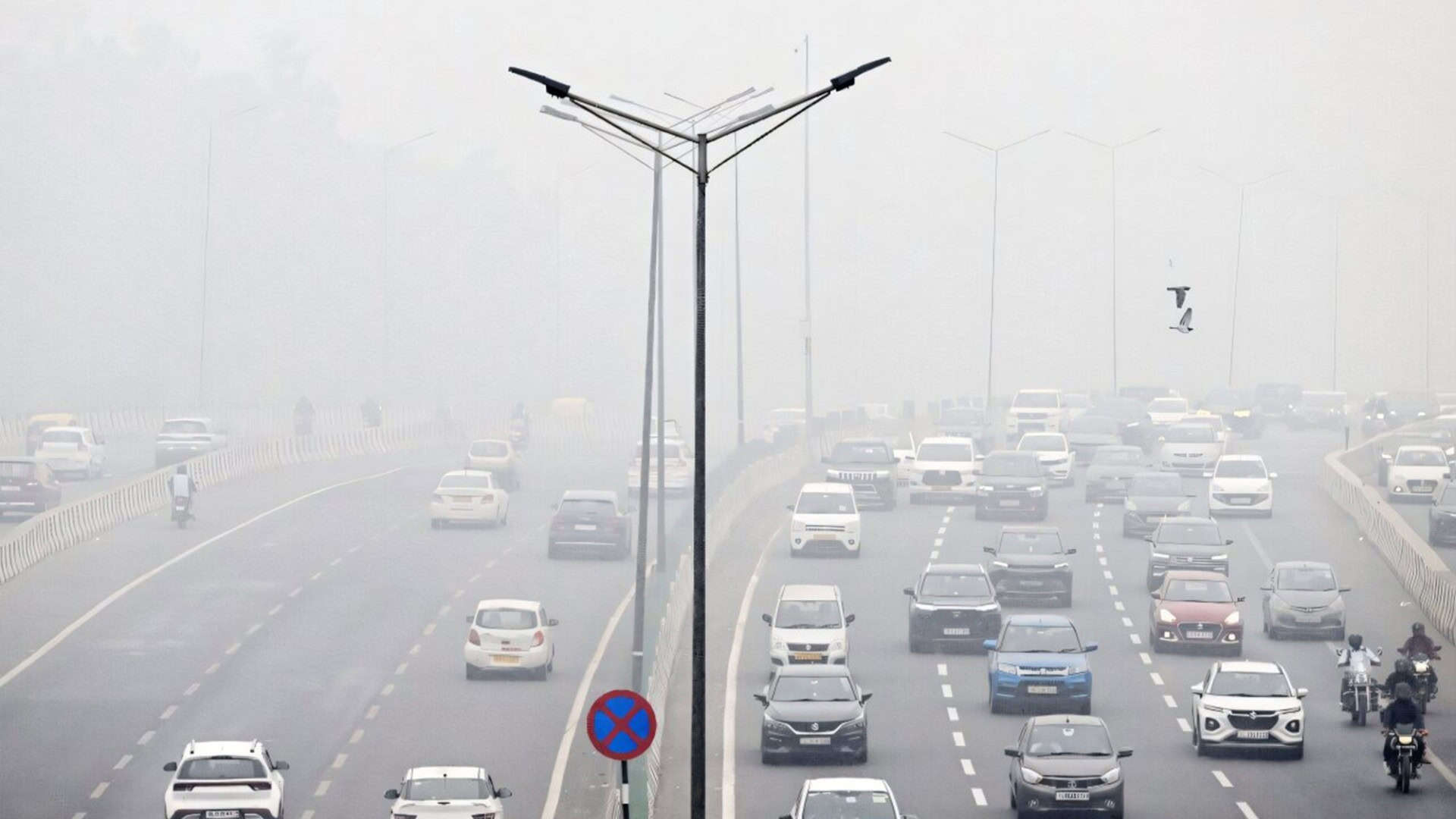 Avenida de Nova Déli coberta por fumaça
