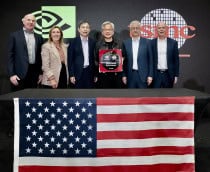 Jensen Huang e outros representantes de Nvidia e TSMC atrás de uma mesa com a bandeira dos EUA; atrás deles, um cartaz com os logos das duas empresas