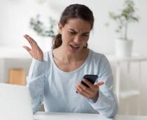 Mulher jovem frustrada olhando para o celular