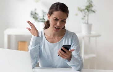 Mulher jovem frustrada olhando para o celular