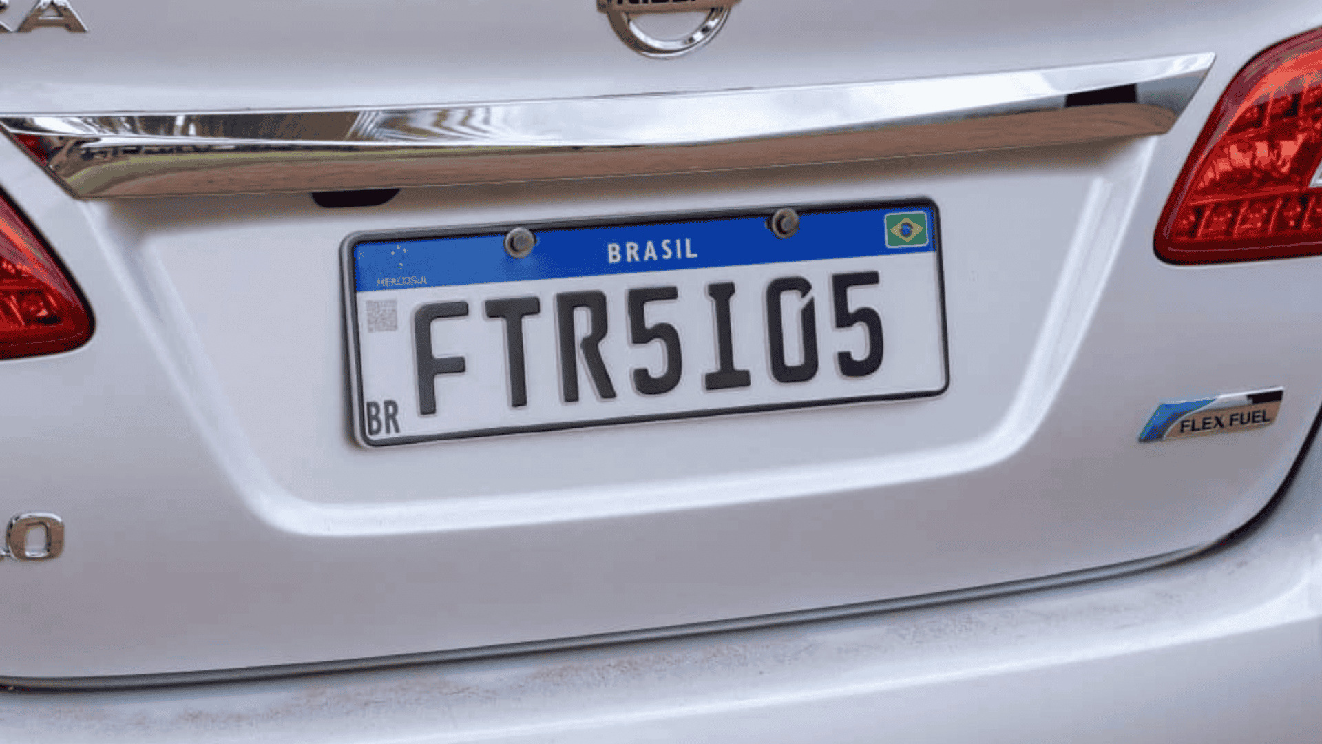 Placas Mercosul em um carro branco, com fundo branco, faixa azul superior e caracteres pretos