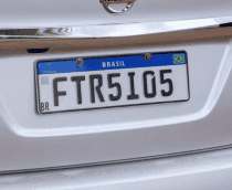 Placas Mercosul em um carro branco, com fundo branco, faixa azul superior e caracteres pretos