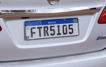 Placas Mercosul em um carro branco, com fundo branco, faixa azul superior e caracteres pretos