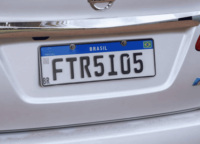 Placas Mercosul em um carro branco, com fundo branco, faixa azul superior e caracteres pretos