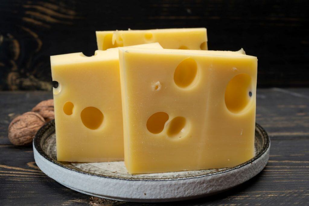 Como a ciência desvendou a origem dos buracos do queijo suíço Por mais de um século, os cientistas tentaram decifrar um dos mistérios mais saborosos da Suíça: de onde vêm os buracos do queijo suíço, do tipo emmental? No início do século XX, acreditava-se que eles surgiam durante a fermentação, quando bactérias liberavam dióxido de carbono e formavam bolhas na massa do queijo. Como a ciência desvendou a origem dos buracos do queijo suíço
