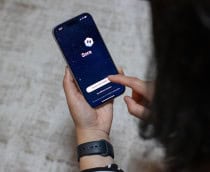 Mulher olhando para o app do Sora em um smartphone que ela está segurando