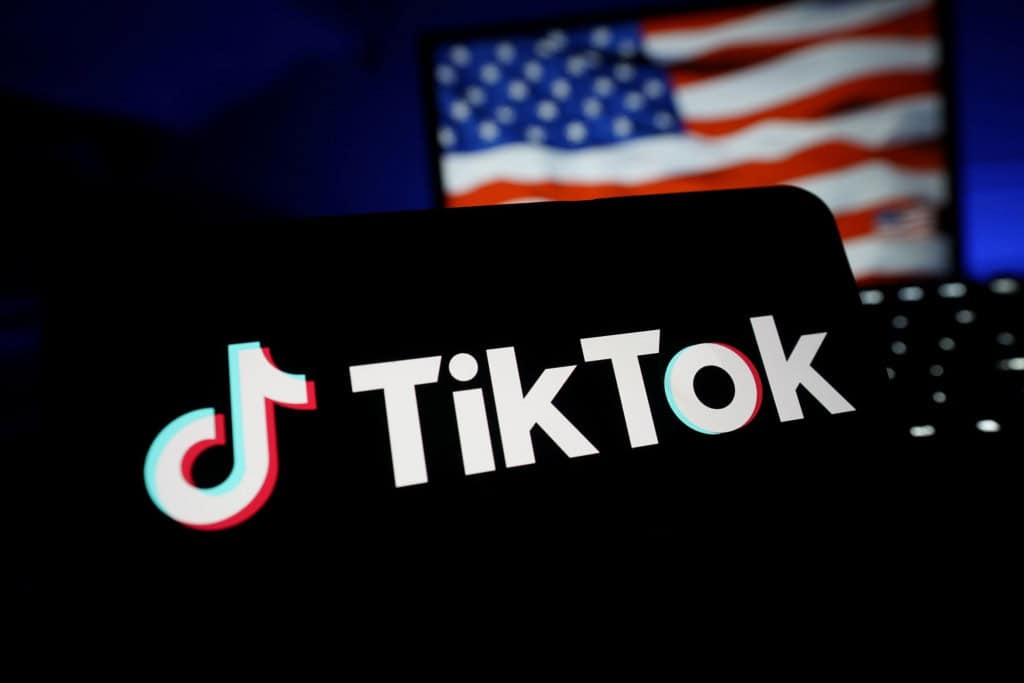 TikTok: acordo pode ser selado na Coreia do Sul, diz Casa Branca 4 Bandeira dos EUA em contraste com o logo do TikTok