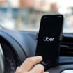 motorista da uber com o aplicativo aberto no celular dentro do carro