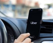 motorista da uber com o aplicativo aberto no celular dentro do carro