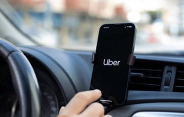 motorista da uber com o aplicativo aberto no celular dentro do carro