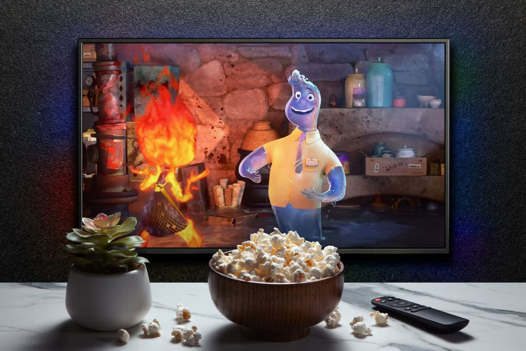Imagem mostra cena de animação em uma tela de TV, Trailer ou filme da Elemental na tela da TV. TV com controle remoto, tigela de pipoca e vasinho de planta doméstica