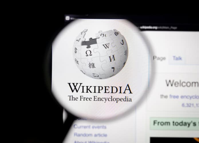 Logo do Wikipedia exibido em sua página oficial e ampliado por uma lupa