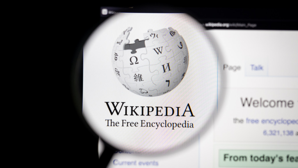 Logo do Wikipedia exibido em sua página oficial e ampliado por uma lupa