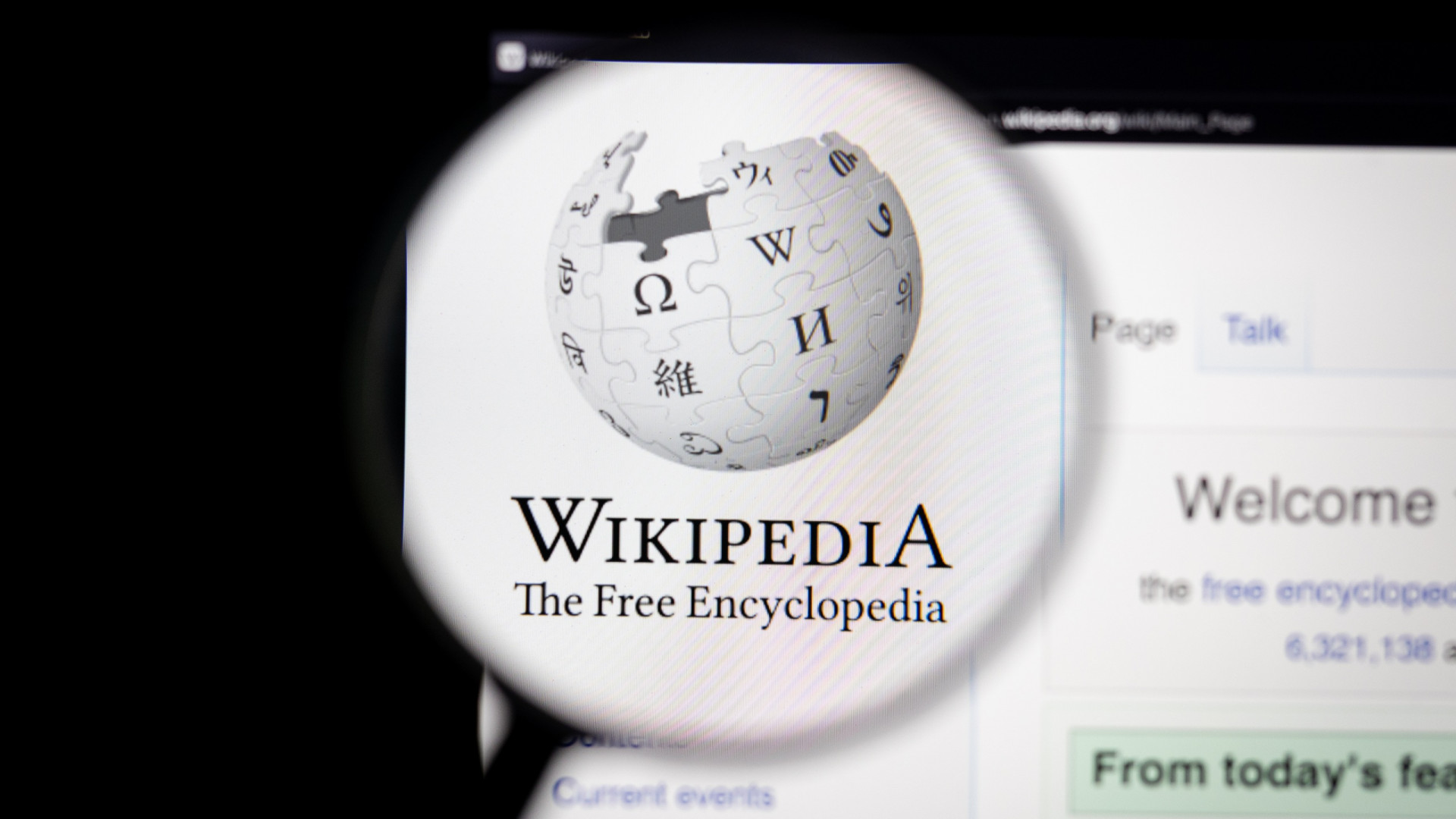 Logo do Wikipedia exibido em sua página oficial e ampliado por uma lupa