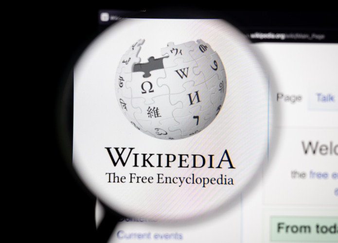 Logo do Wikipedia exibido em sua página oficial e ampliado por uma lupa