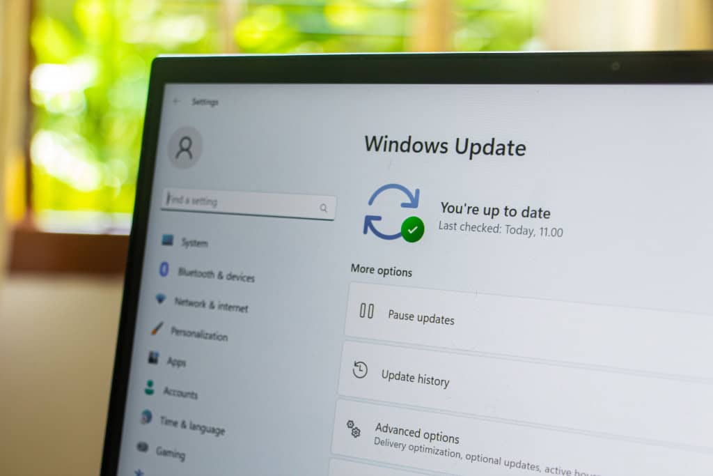 Indicador do Windows Update na tela do monitor exibindo o sistema operacional Windows atualizado com uma marca de seleção verde indicando "atualizado" nas configurações do Windows